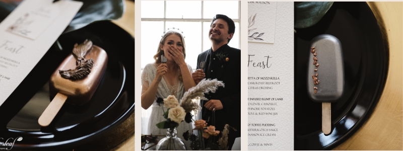Bride and groom laughing while eating chocolate brownie cakesicles at wedding table with black feather decor