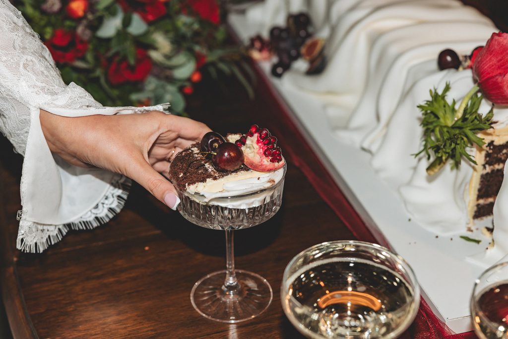 Vegan chocolate wedding cake in martini glass showing layered sponge with cherries and strawberry